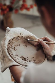 Close Up of Female Pottery Artist at Work, Woman Creating Patterns on Clay Plate, Art Work in Process