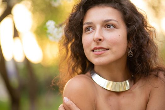 Portrait of a young sexy brunette girl with a necklace around her neck.