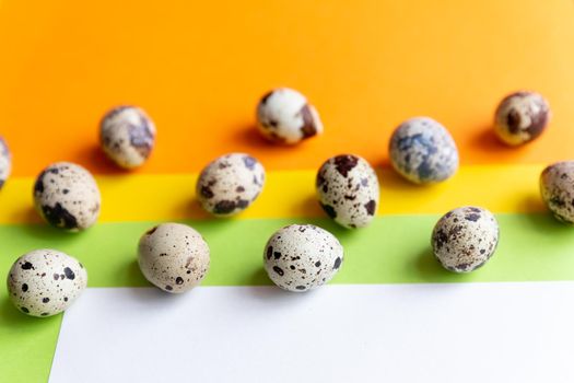 small spotted quail eggs scattered on beige cloth and bouquet of dried blue gypsophila flowers.