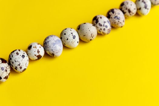 small spotted quail eggs scattered on beige cloth and bouquet of dried blue gypsophila flowers.