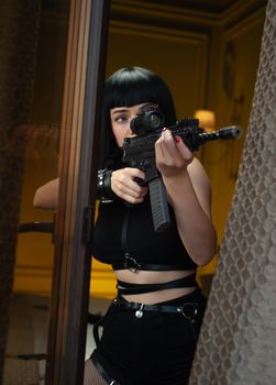 the female hitman in a hotel near the window aims an automatic rifle with a telescopic sight at the victim committing murder