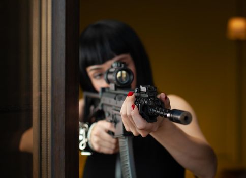 the female hitman in a hotel near the window aims an automatic rifle with a telescopic sight at the victim committing murder