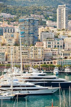 Aerial view of port Hercules at sunset, mega yachts are moored in marina near yacht club of Monaco, view of city life from old town, a lot of mega yachts and boats. High quality photo