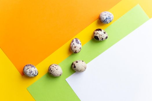 small spotted quail eggs scattered on beige cloth and bouquet of dried blue gypsophila flowers.