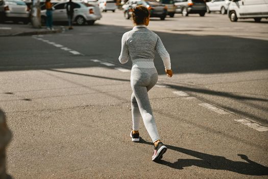 Female jogger exercising outdoors on a sunny day. Sports, active lifestyle concept