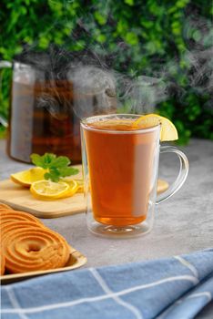 Tea hot drink with steam on old background in composition on the table.