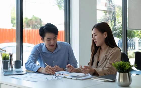 business partnership coworkers discussing a financial planning graph and company during a budget meeting in office room.