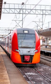 Modern high-speed train moves fast along the platform. People are waiting for the train at the station, public transport.