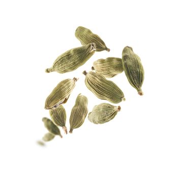 Cardamom pods levitate on a white background.