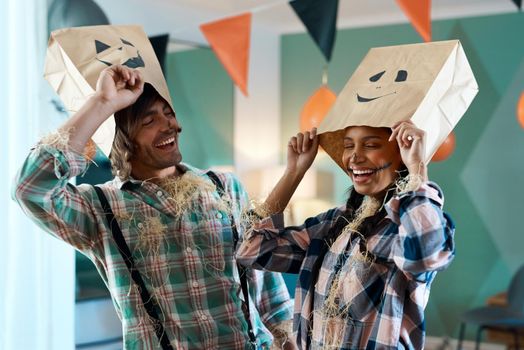 Shot of a young couple with paper bags over their heads at home.