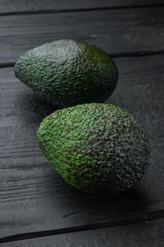 Ripe pair of green avocado set, on black wooden background