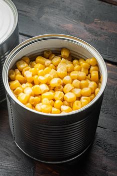 Canned corn in can, on old dark wooden table background