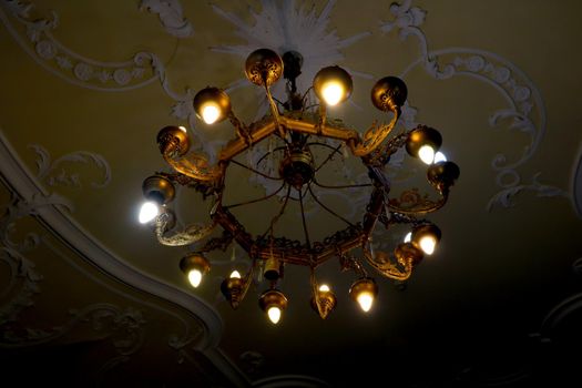 A beautiful old metal chandelier hangs from the ceiling