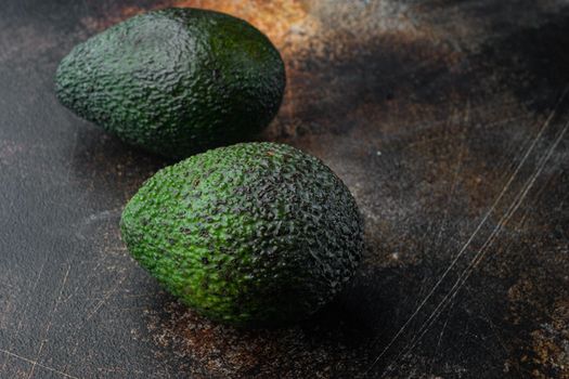 Ripe pair of green avocado set, on old dark rustic background with copy space for text