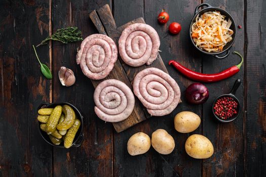 Fried Bavarian German Nürnberger sausages with sauerkraut, mashed potatoe, on old dark wooden table background, top view flat lay