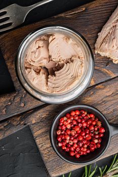 Canned tuna fillet meat in olive oil, on black background, top view