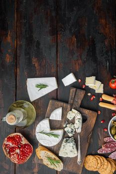 Appetizers table with differents antipasti set, on dark wooden background, flat lay with copy space for text