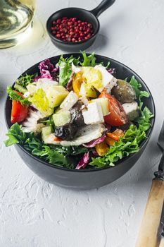 Greek salad with tomato pepper, olives and feta cheese, on white background