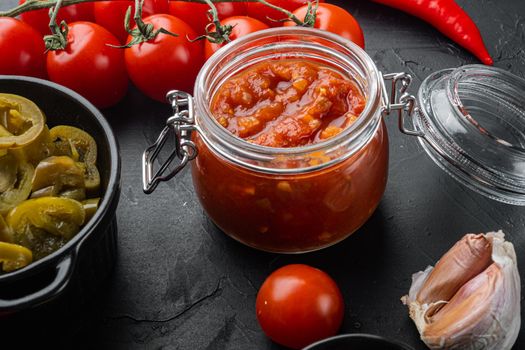 Mexican salsa sauce jar, on black background