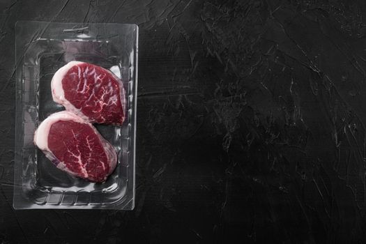 Beef steak pack set, on black dark stone table background, top view flat lay, with copy space for text