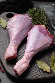 Fresh turkey legs with ingredients for cooking set, on black dark stone table background