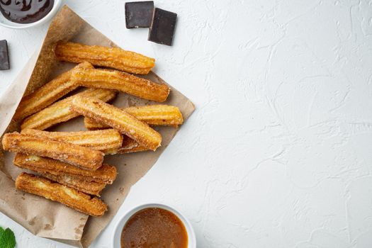 Churros sprinkled with powdered sugar set, on white background, top view flat lay with space for text, copyspace