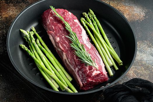 Beef fillet mignon cut raw set, on frying cast iron pan, on old dark rustic background