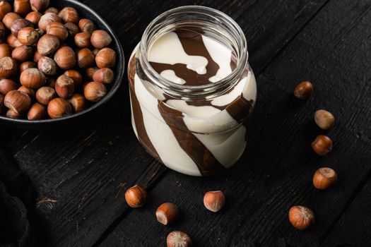 Chocolate Hazelnut Spread set, on black wooden table background, with copy space for text