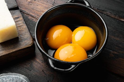 Bright yellow egg yolks set, on old dark wooden table