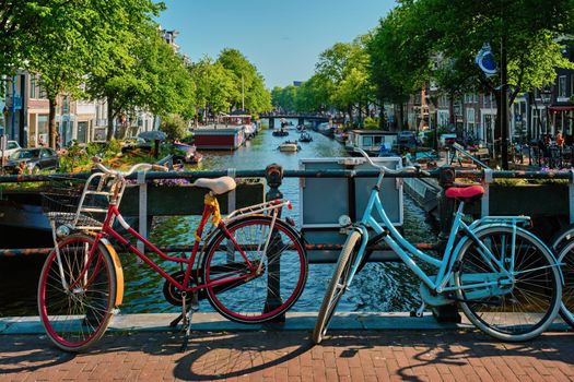 Typical Amsterdam view - Amsterdam canal with boats and bicycles on a bridge. Amsterdam, Netherlands