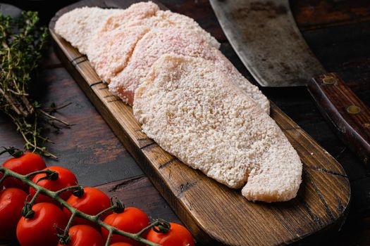 Breaded chicken steak, on old dark wooden table background