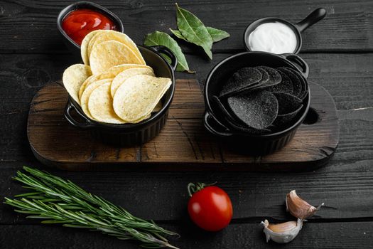 Home made potato chips set, on black wooden background