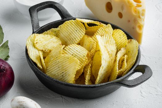 Potatoe chips set with Cheese and Onion, with dipping sauces tomato dip sour cream, on white stone surface