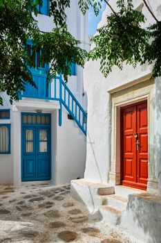 Picturesque scenic narrow Greek streets with traditional whitewashed houses with blue doors windows of Mykonos town in famous tourist attraction Mykonos island, Greece