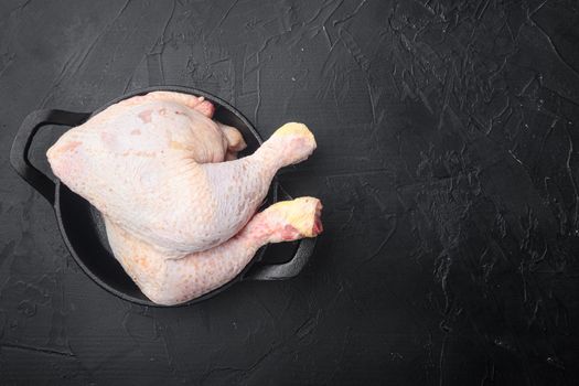 Fresh Chicken drumstick set, in frying cast iron pan, on black stone background, top view flat lay, with copy space for text