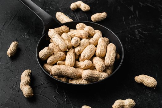 Peanuts serving to make oil, peanut butter set, on black dark stone table background