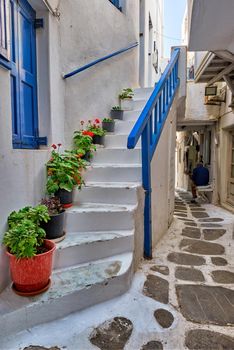 Picturesque scenic narrow Greek streets with traditional whitewashed houses with blue doors windows of Mykonos town in famous tourist attraction Mykonos island, Greece