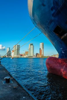 View of Rotterdam skyscrapers skyline from under cargo vessel moored to the quay of Nieuwe Maas river. Rotterdam, the Netherlands