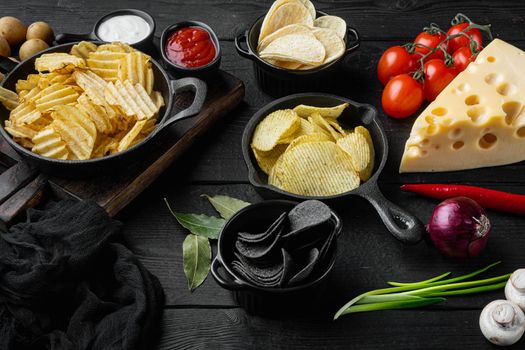 Variation different potato chips set, on black wooden background