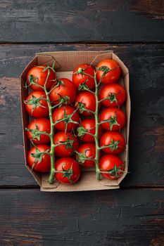 Ripe cherry tomatoes, on dark wooden background, top view