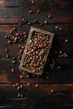 Pine wild organic nut set, on old dark wooden table background, top view flat lay