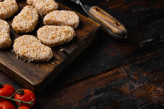 Chicken nuggets uncooked, on old dark wooden table background, with copy space for text