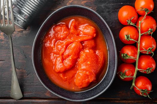 Whole canned tomatoe, on old dark wooden table background, top view flat lay