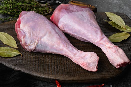 Raw turkey thigh with spices set, on black dark stone table background