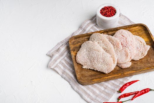 Breaded chicken steak, on white stone table background, top view flat lay, with copy space for text