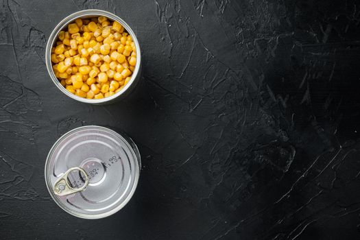 Canned sweet corn in can, on black background, top view flat lay with copy space for text