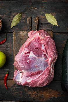 Raw pork cutlet with oil and spices for grill or cooking set, with apple dry cider, on old dark wooden table background, top view flat lay