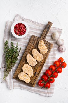 Instant food raw chicken nuggets ready for cooking, on white stone table background, top view flat lay