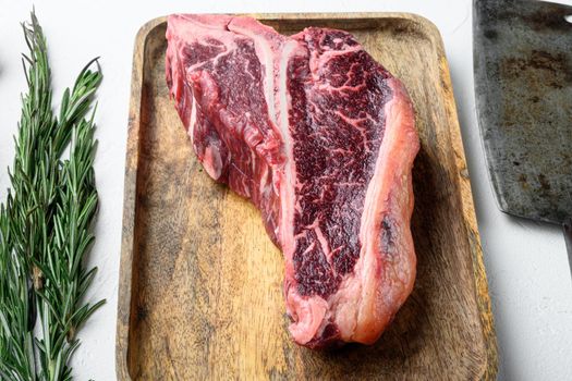 Raw t bone steak with ingredients set, on white stone background