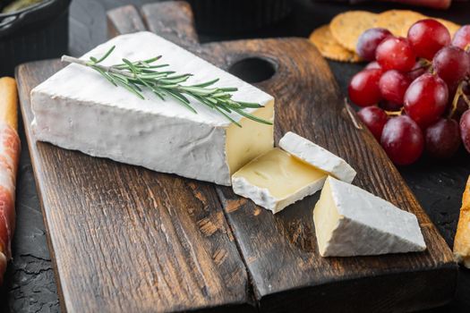 Delicious brie cheese piece, on black background